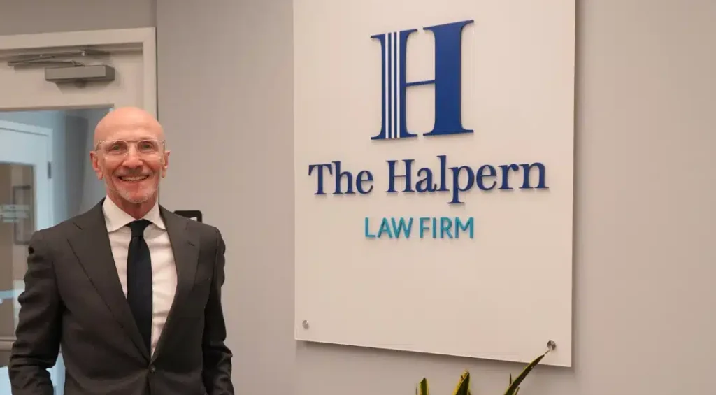 Photo of Dave in Bryn Mawr office in front of Halpern Law Firm sign