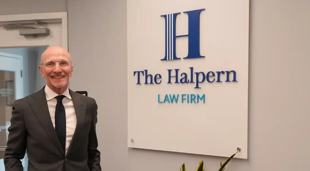 Photo of Dave in Bryn Mawr office in front of Halpern Law Firm sign