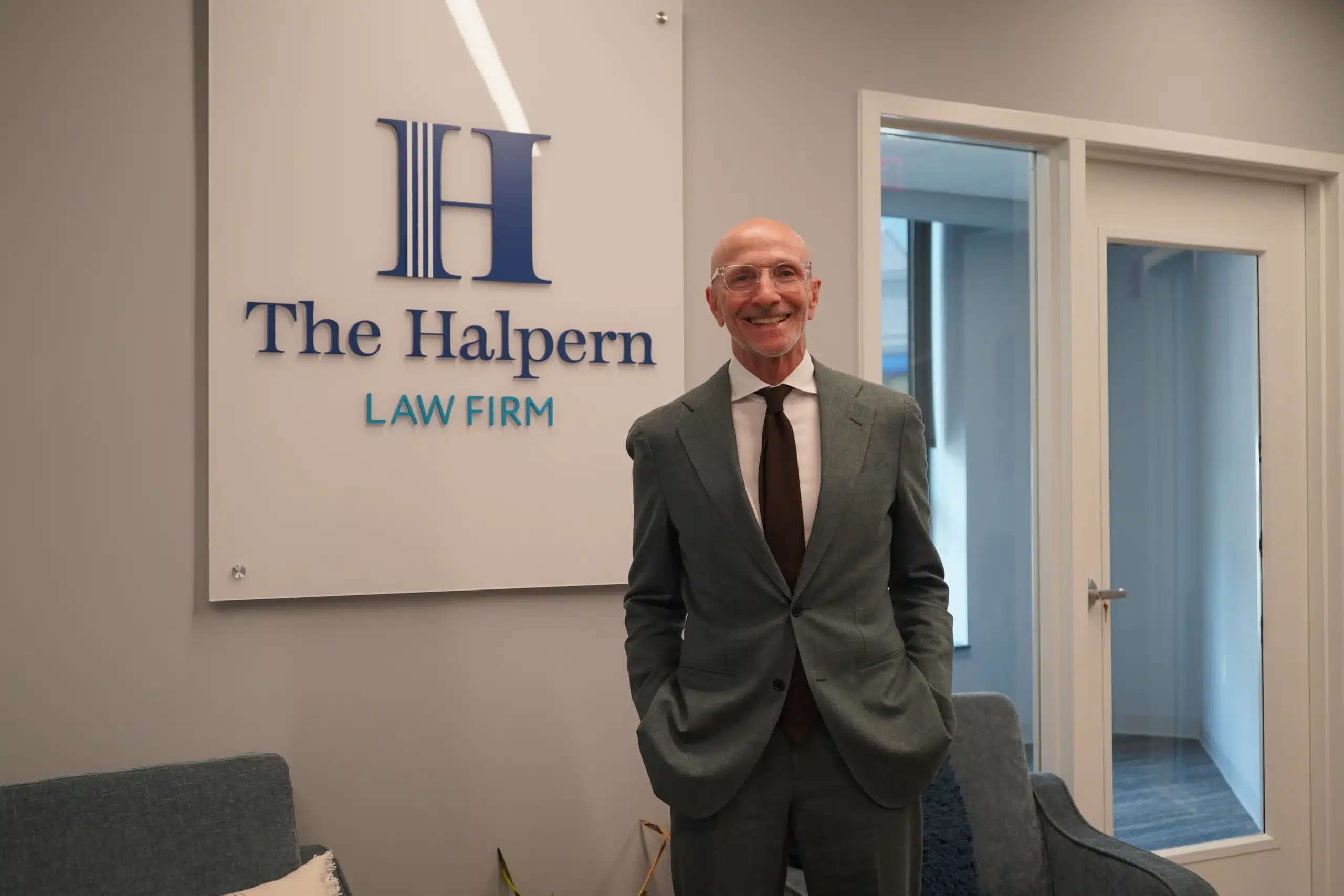 Attorney Dave Halpern standing in front of the Halpern Law Firm sign